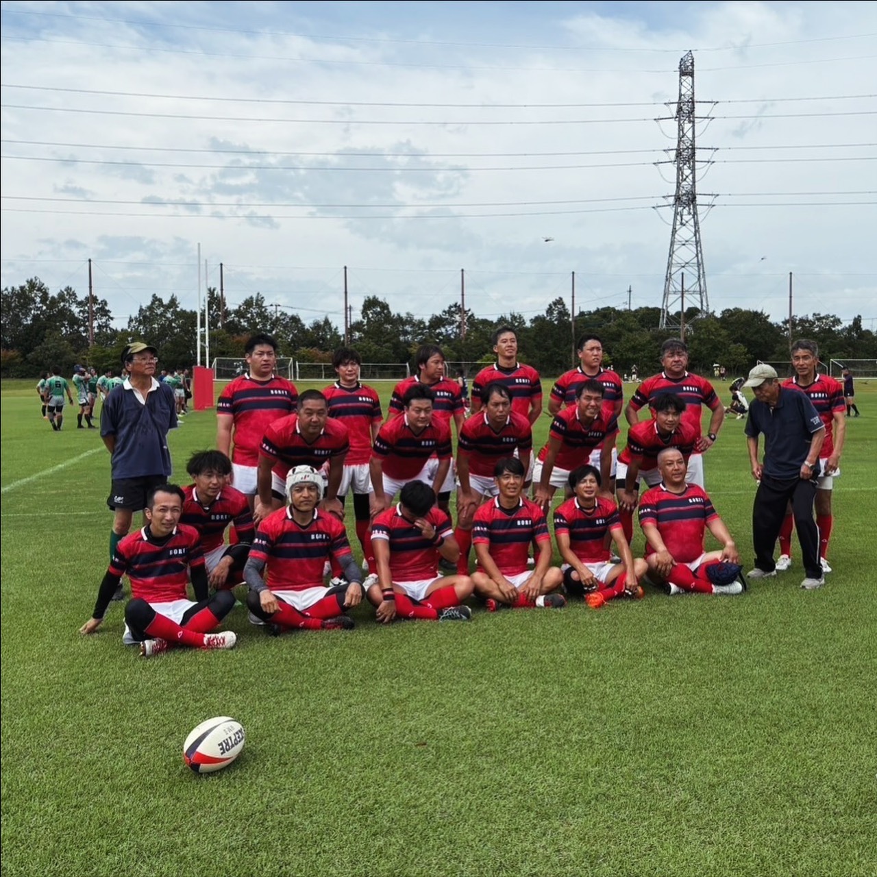 AGRIFALLS R.F.C. チーム集合写真 — 赤×ネイビーのジャージ姿でグラウンドに集合