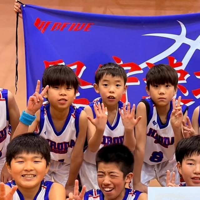 広田SUNRISE — 大会前、旗の前で笑顔で並ぶ子どもたち