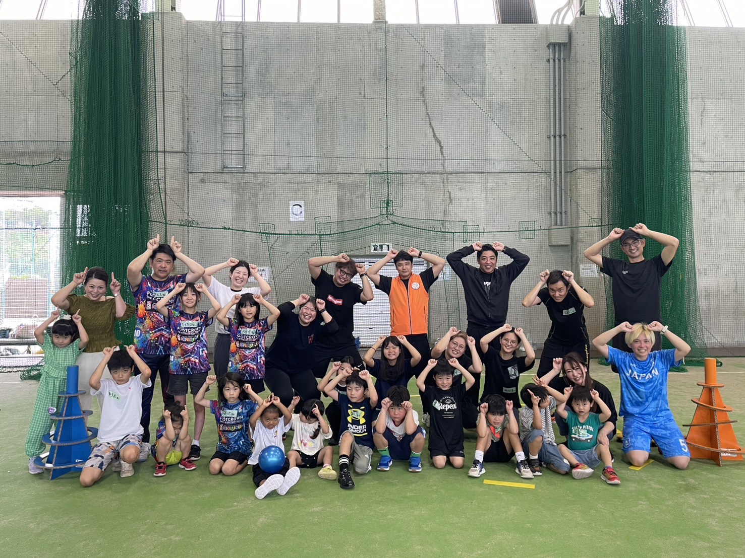 沖縄市スポーツ鬼ごっこ愛好会 — 体育館で20人以上のメンバーが鬼のポーズで集合写真