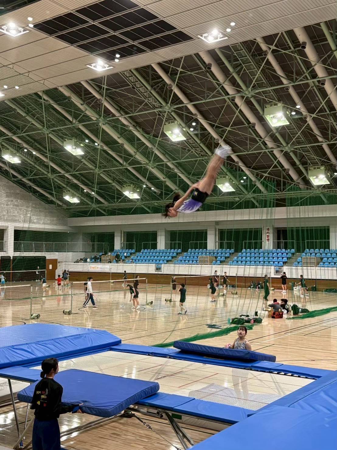 体育館で高く跳ぶ選手