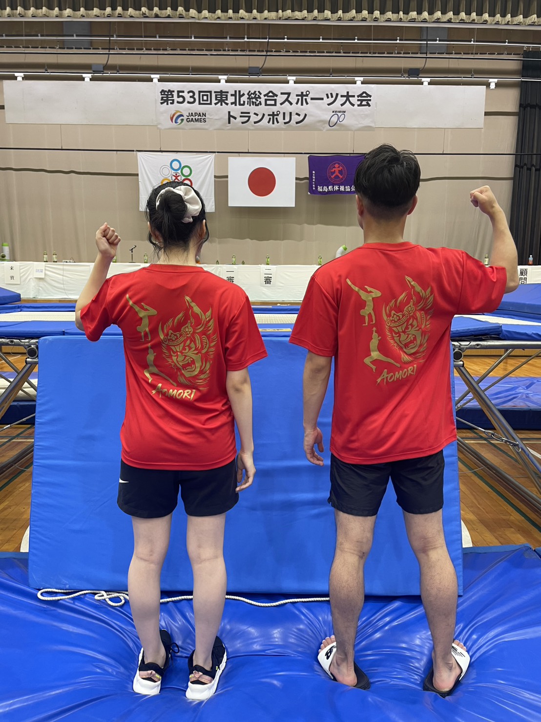 トランポリンアカデミー — AOMORI と刺繍された赤いユニフォーム姿の選手2名、第53回東北総合スポーツ大会（JAPAN GAMES）の会場にて
